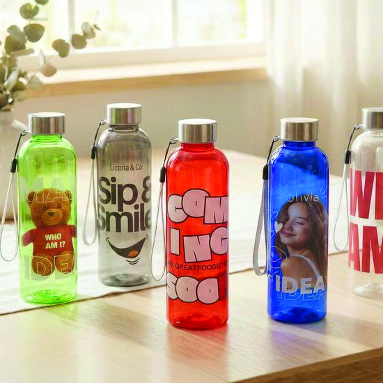 Pięć kolorowych bidonów z pełnokolorowym nadrukiem logo stojących w rzędzie na blacie — bidony reklamowe z logo dla firm