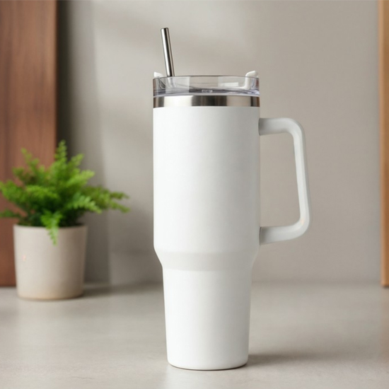 Biały kubek termiczny z uchem i słomką na blacie kuchennym