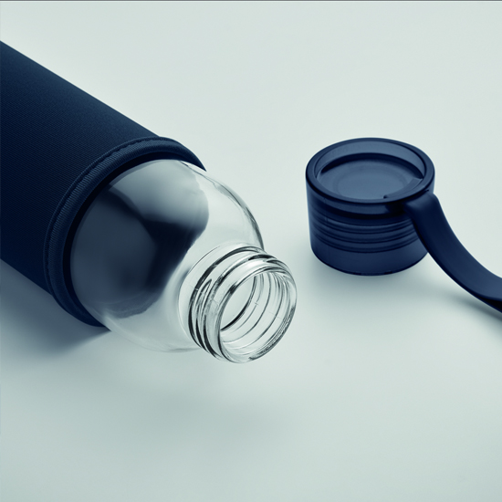 Szklana butelka z nadrukiem logo firmy w silikonowej osłonie na biurku w nowoczesnym biurze